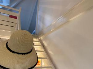 um chapéu sentado no topo de uma escada ao lado de um frigorífico em La Forestière - Face au 10 em Neufchâtel-Hardelot