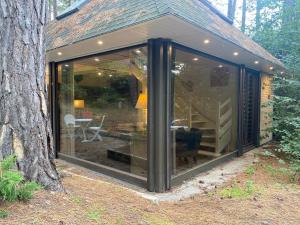 Una gran extensión de vidrio de una casa en el bosque. en La Forestière - Face au 10, en Neufchâtel-Hardelot