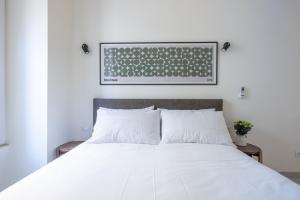 a bedroom with a white bed with a keyboard on the wall at Vatican Apartment near Metro Ottaviano in Rome