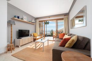 a living room with a couch and a tv at Apartamento Lortal in Alcudia