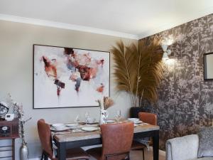 a dining room with a table and a painting on the wall at Shirleys Place in Boston Spa