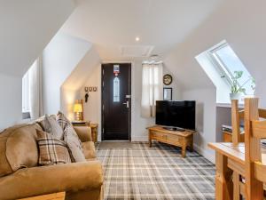 a living room with a couch and a tv at The Old Stables - Uk46338 in Canisbay