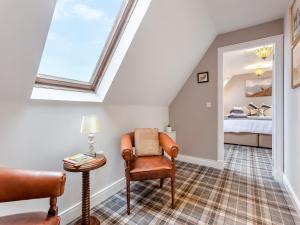 a attic room with a chair and a bed at The Old Stables - Uk46338 in Canisbay