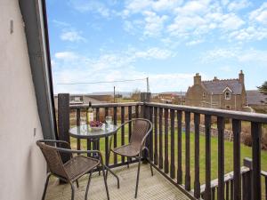 a balcony with a table and chairs on a deck at The Old Stables - Uk46338 in Canisbay
