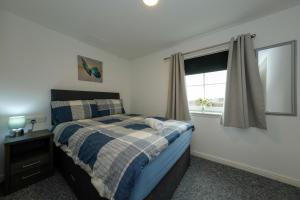 a bedroom with a bed and a window at Pure Apartments 2 Bed Duloch - Dunfermline in Fife