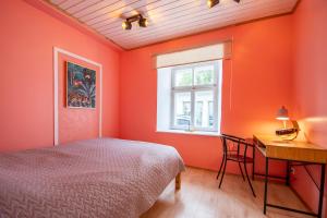 a bedroom with orange walls and a bed and a desk at Kauba 6-5 Apartment in Kuressaare
