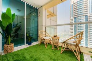a balcony with two chairs and a table with grass at Dubai Marina - 1BHK Apartment in Dubai