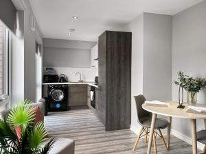 a living room with a table and a kitchen at Apartment 205 in Sheffield