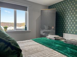 a bedroom with a bed with a green accent wall at Apartment 205 in Sheffield