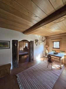 a living room with a wooden ceiling and a table at Fuchswirt Kelchsau Landgasthof-Hotel in Hopfgarten im Brixental