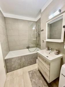 uma casa de banho com uma banheira, um lavatório e um chuveiro em Cozy Studios and Flats - Coresi Mall #Brasov em Brasov