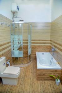 ein Badezimmer mit einer Dusche, einem WC und einer Badewanne in der Unterkunft Muthu villa in Ambalangoda