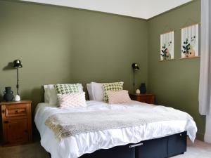 1 dormitorio con 1 cama con sábanas y almohadas blancas en Main Street Flat C-uk46563, en Prestwick
