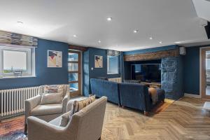 a living room with two chairs and a television at Goferydd, South Stack, Anglesey, 4 bed luxury home, hot tub, dog friendly in Holyhead