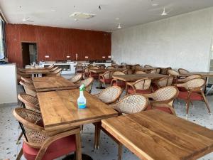 Habitación con mesas y sillas de madera y una botella. en Swanotel Gachibowli, en Gachibowli