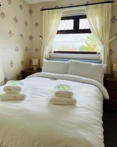 ein Schlafzimmer mit einem weißen Bett und Handtüchern darauf in der Unterkunft 8 PEMBERTON Entire 3 bed in Newry Mourne and Down Sleeps 5 in Downpatrick