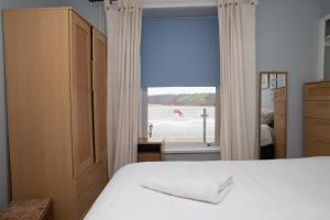 a bedroom with a bed and a window with a view at No. 1 Cliffside New Quay in New Quay