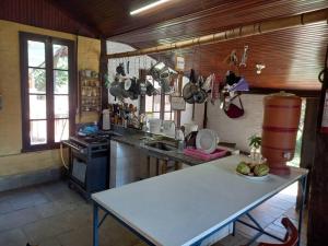 a kitchen with a white table in a room at Sitio Humanaterra: natureza e acolhimento. in São Lourenço da Serra
