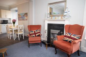 a living room with two chairs and a fireplace at No. 1 Cliffside New Quay in New Quay
