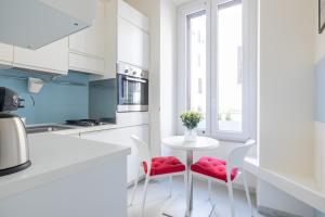 a white kitchen with a white table and chairs at Vatican Apartment near Metro Ottaviano in Rome
