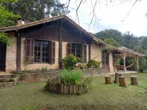 une maison avec un jardin en face dans l'établissement Sitio Humanaterra: natureza e acolhimento., à São Lourenço da Serra