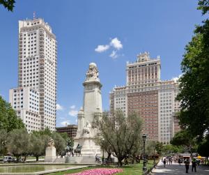 un parco con una statua di fronte a edifici alti di Apartamentos Day Madrid BEATAS Centro Gran Via Sol Malasaña a Madrid