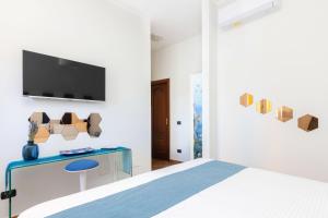 a bedroom with a bed and a tv on a wall at Casale Antonietta in Sorrento