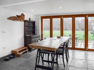 uma sala de jantar com uma mesa de madeira e cadeiras em Uk46591 - Polecat Barn em Wivelsfield Green