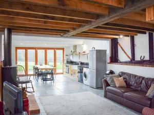 een keuken en een woonkamer met een bank en een tafel bij Uk46591 - Polecat Barn in Wivelsfield Green