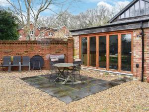 een patio met een tafel en stoelen voor een gebouw bij Uk46591 - Polecat Barn in Wivelsfield Green