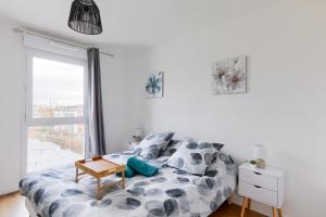 a bedroom with a bed with a table and a window at Confort Moderne Argenteuil – Proche Paris in Argenteuil