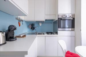 a kitchen with white cabinets and a sink at Vatican Apartment near Metro Ottaviano in Rome