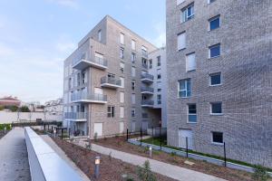 un condominio accanto a un edificio in mattoni di Confort Moderne Argenteuil – Proche Paris ad Argenteuil
