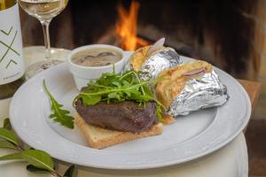 a plate of food with a hamburger and bread with sauce at St. Florian Restaurant & Pension in Vrakúň