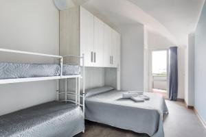 a small bedroom with two bunk beds and a window at Hotel Alexander in San Mauro a Mare