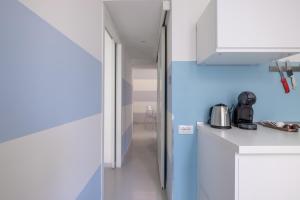 a kitchen with white counters and a blue wall at Vatican Apartment near Metro Ottaviano in Rome +12 photos