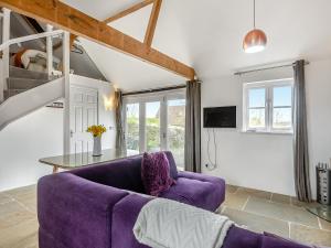 - un salon avec un canapé violet et une table dans l'établissement Waveney Valley View, à Burgh Saint Peter