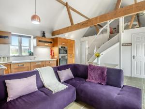 a living room with a purple couch in a kitchen at Waveney Valley View in Burgh Saint Peter
