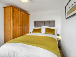 - une chambre avec un grand lit blanc et des oreillers jaunes dans l'établissement Waveney Valley View, à Burgh Saint Peter