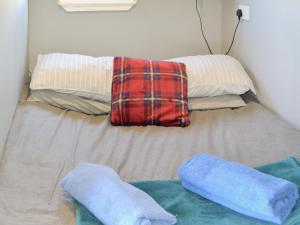 łóżko z 2 poduszkami i 2 ręcznikami w obiekcie The Shepherds Hut - Uk46633 w mieście Culbokie