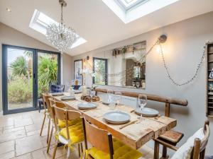 a dining room with a long wooden table and chairs at Stone Cottage in Blofield