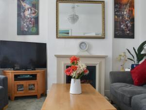 a living room with a vase of flowers on a coffee table at Avondale in Clacton-on-Sea