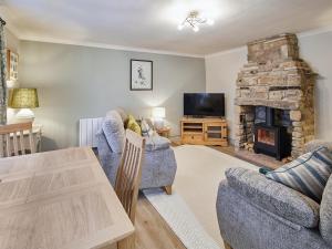 a living room with two couches and a fireplace at Cobblers Cottage in Barnard Castle