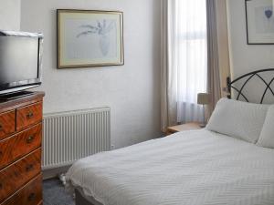 a bedroom with a bed and a dresser with a television at Avondale in Clacton-on-Sea