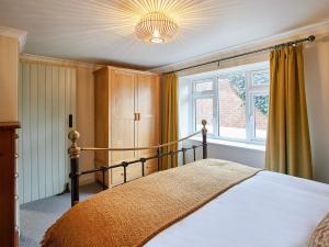 um quarto com uma cama e uma grande janela em Cobblers Cottage em Barnard Castle