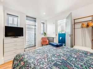 a bedroom with a bed and a flat screen tv at Ethelbert Apartment in Westgate-on-Sea