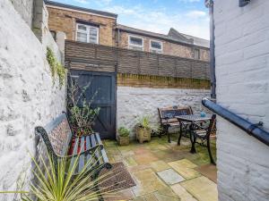 a patio with a table and chairs and a building at Ethelbert Apartment in Westgate-on-Sea