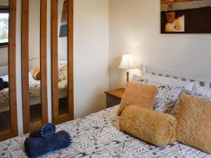 Acle的住宿－The Stables，一间卧室配有一张带两个枕头和镜子的床