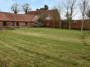 un patio frente a una casa de ladrillo en The Stables, en Acle