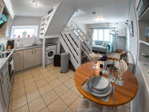 een keuken en eetkamer met een tafel en een trap bij Apple Blossom Cottage - Uk46648 in Cheddar